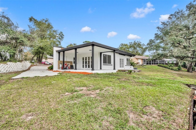 rear view of property featuring a yard, a patio area, and french doors