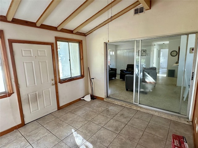 foyer featuring tile patterned floors and lofted ceiling with beams