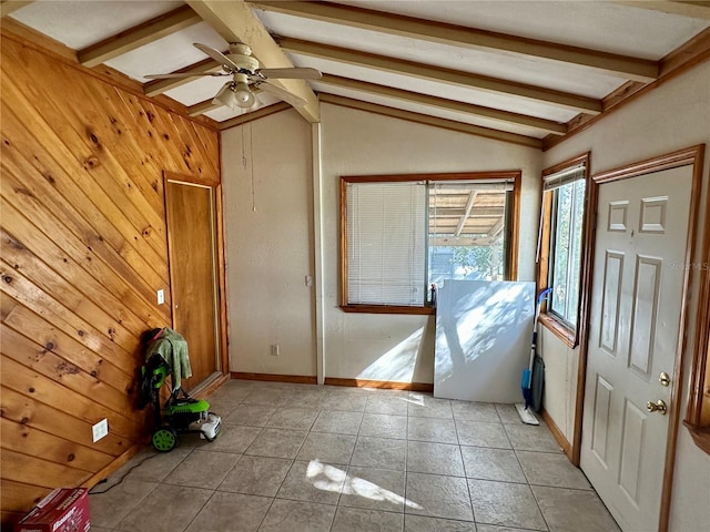 entryway featuring vaulted ceiling with beams, wood walls, light tile patterned floors, and ceiling fan