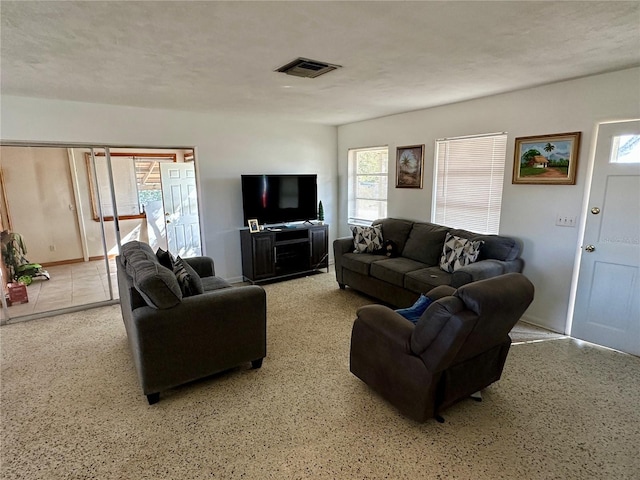 living area featuring visible vents and a textured ceiling