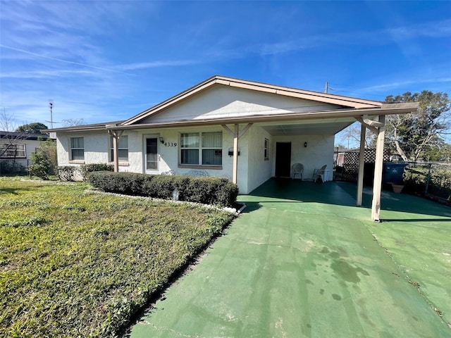 back of property featuring a lawn and a carport