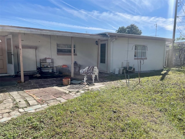 rear view of house featuring a lawn and a patio area