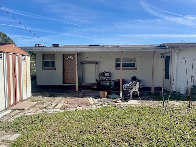 rear view of house featuring solar panels, a shed, and a lawn