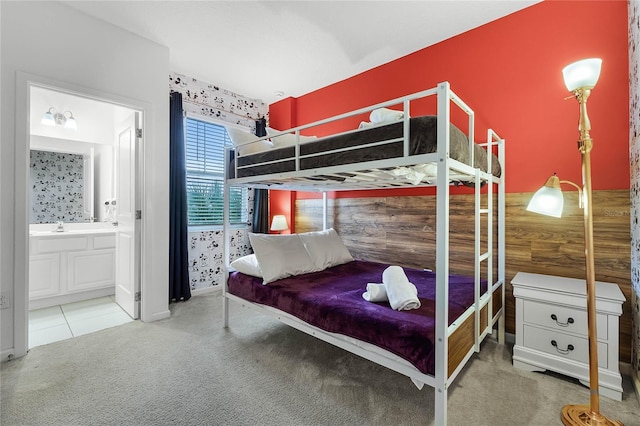 carpeted bedroom featuring ensuite bathroom and sink