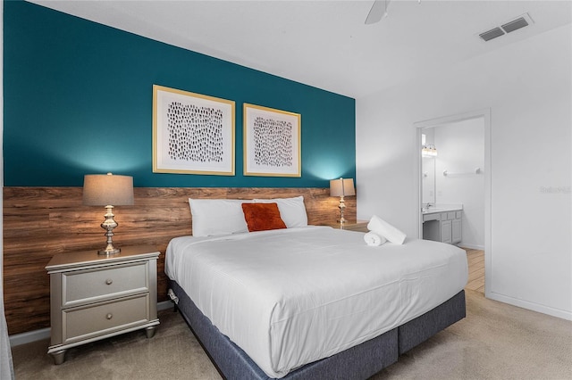 carpeted bedroom featuring connected bathroom and ceiling fan