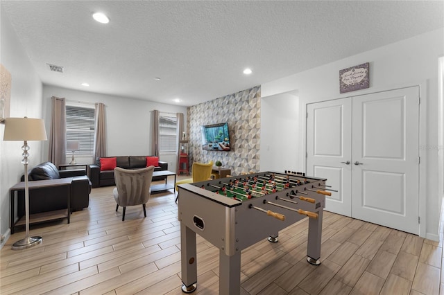 recreation room featuring a textured ceiling