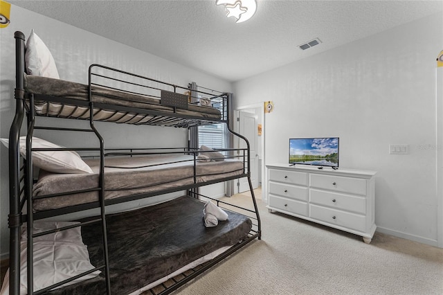 carpeted bedroom featuring a textured ceiling