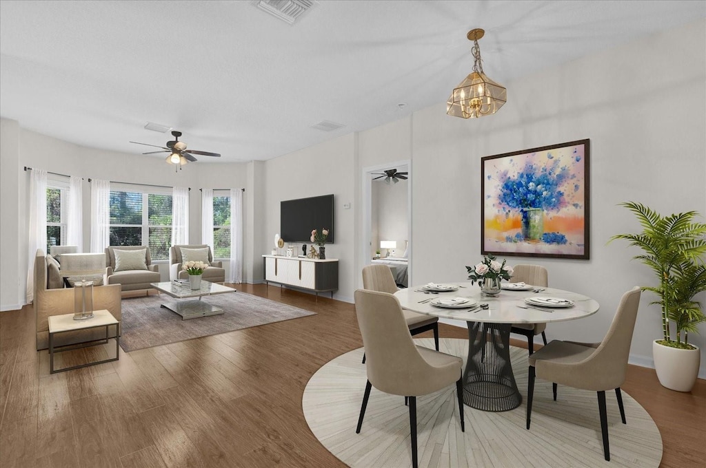 dining room featuring hardwood / wood-style floors and ceiling fan with notable chandelier