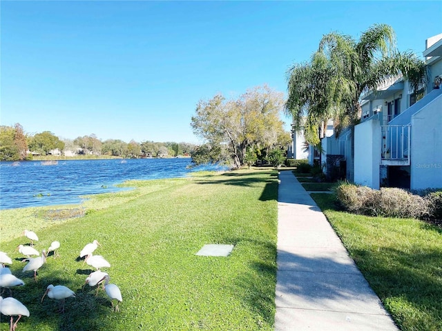 view of home's community featuring a water view and a lawn