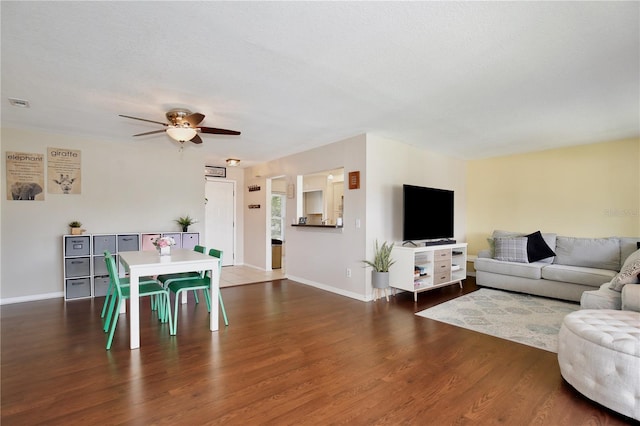 living room featuring a textured ceiling, dark hardwood / wood-style flooring, and ceiling fan