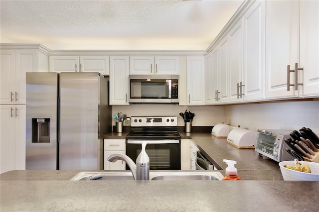 kitchen with sink, white cabinets, stainless steel appliances, and a textured ceiling