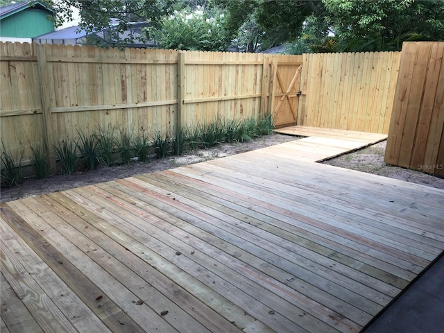 wooden terrace featuring a gate and fence