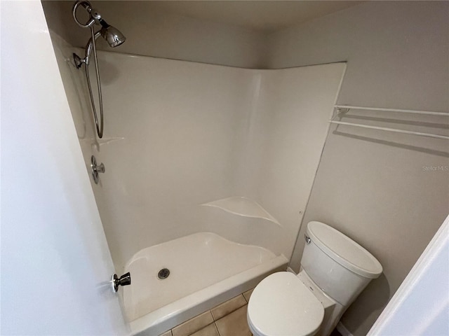 bathroom featuring a shower stall and toilet