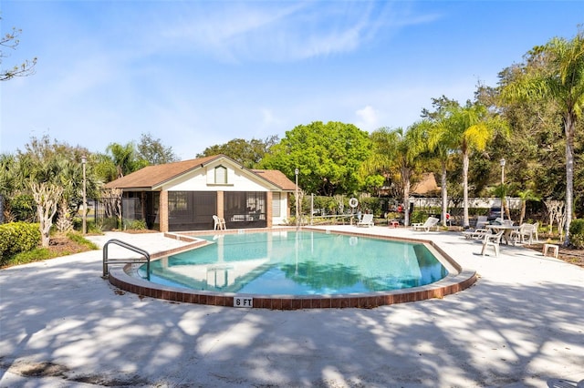 pool with a patio area and fence