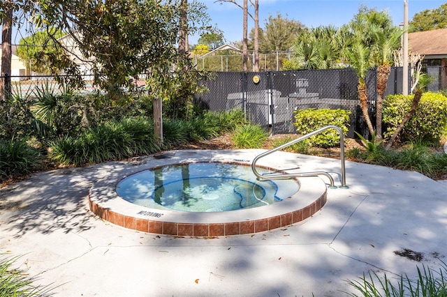 view of swimming pool with a hot tub and fence