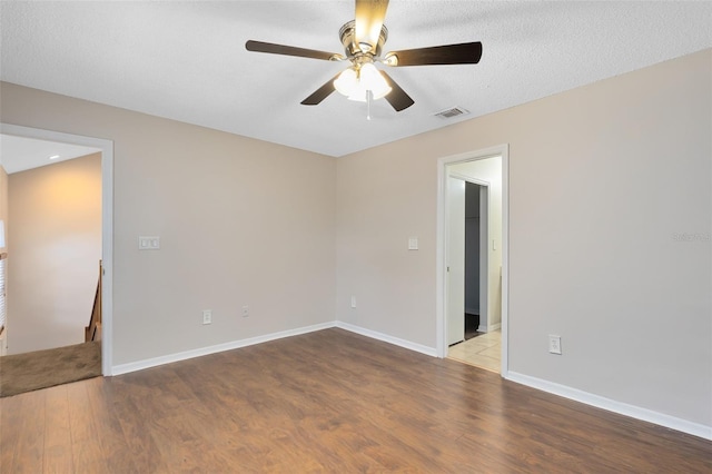 unfurnished room with light wood-style flooring, baseboards, and a textured ceiling