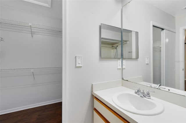 bathroom featuring vanity, baseboards, and wood finished floors