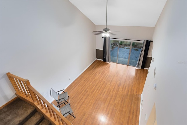 interior space featuring a ceiling fan, baseboards, stairway, and wood finished floors