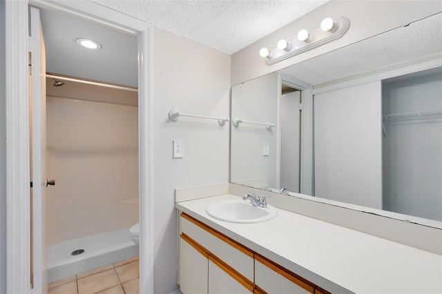 full bathroom with toilet, a stall shower, a textured ceiling, vanity, and tile patterned flooring