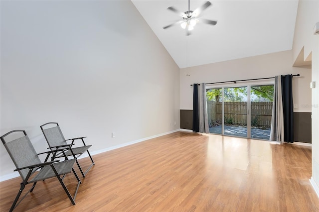 unfurnished room featuring baseboards, light wood-style flooring, high vaulted ceiling, and a ceiling fan