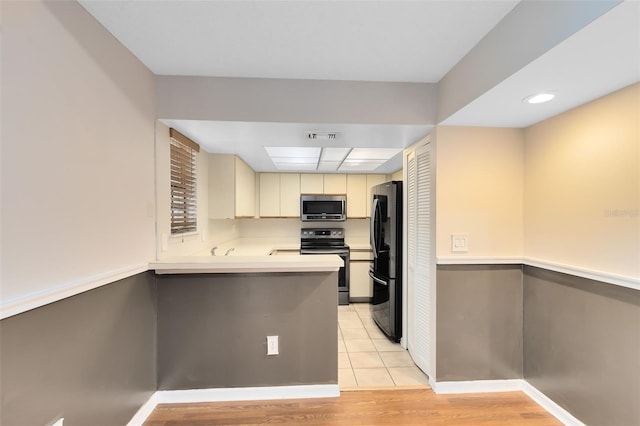 kitchen featuring visible vents, baseboards, light countertops, appliances with stainless steel finishes, and cream cabinetry