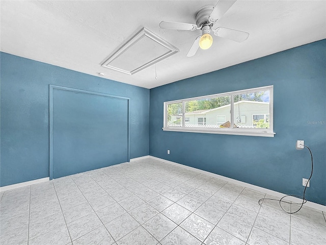 tiled spare room featuring ceiling fan