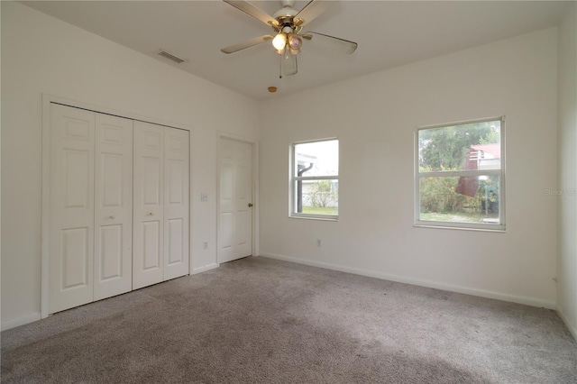 unfurnished bedroom featuring light carpet, ceiling fan, and a closet