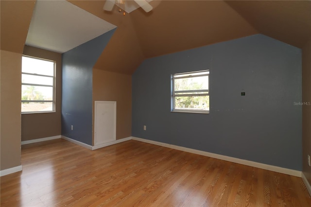 additional living space with ceiling fan, lofted ceiling, and light wood-type flooring