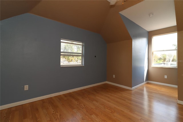 bonus room with vaulted ceiling, a wealth of natural light, and light wood-type flooring