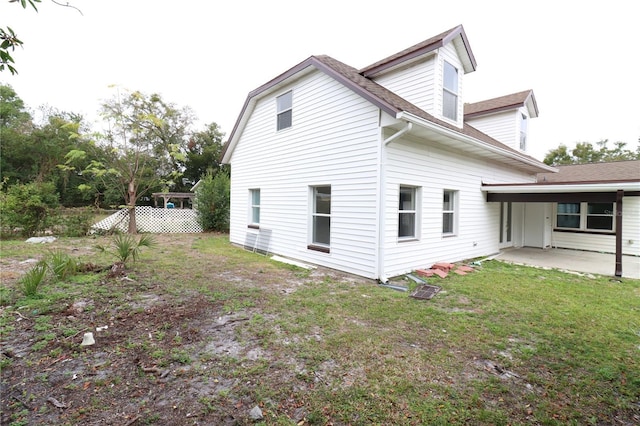 view of side of property featuring a yard and a patio area