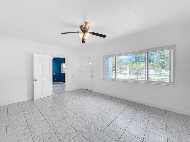 empty room featuring light tile patterned floors and ceiling fan