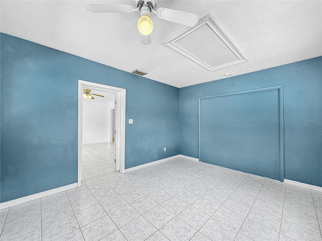 empty room with ceiling fan and light tile patterned floors