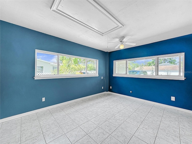 tiled empty room featuring a textured ceiling