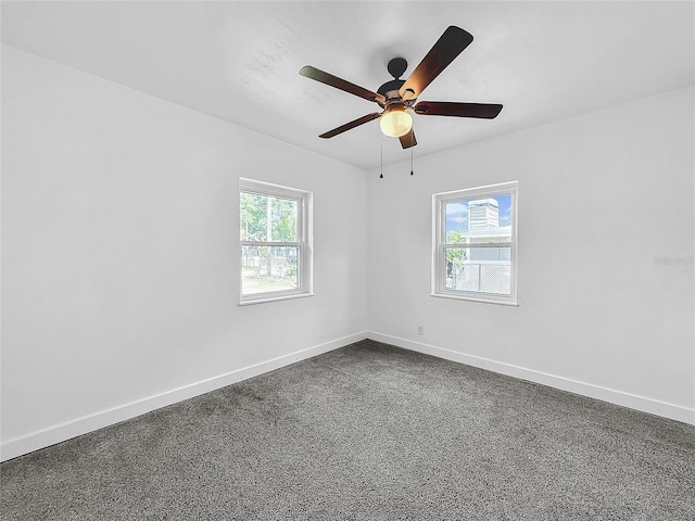 carpeted spare room featuring ceiling fan