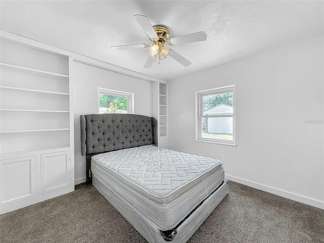 bedroom with multiple windows, ceiling fan, and dark colored carpet