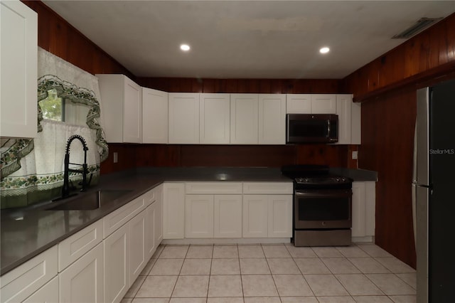 kitchen with light tile patterned floors, stainless steel appliances, sink, and white cabinets