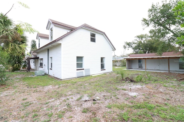 back of property with a yard and a patio