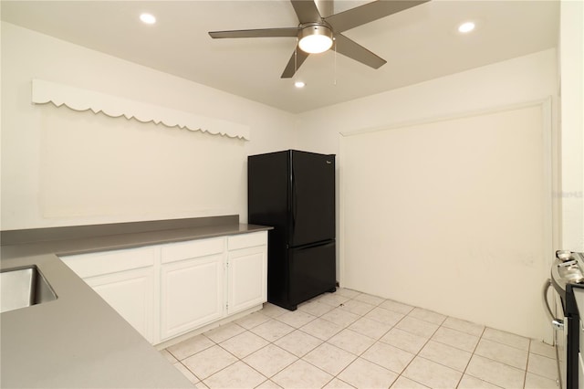 kitchen featuring white cabinetry, stainless steel electric range, light tile patterned floors, black refrigerator, and ceiling fan