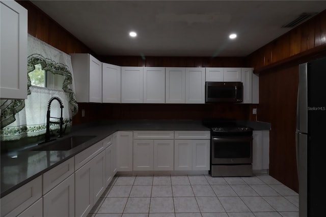 kitchen featuring white cabinetry, sink, light tile patterned flooring, and appliances with stainless steel finishes