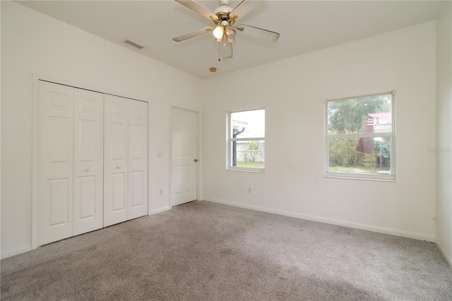 unfurnished bedroom with light carpet, ceiling fan, and a closet