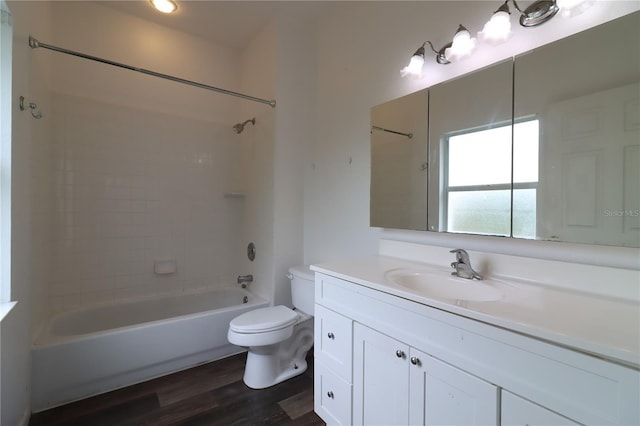 full bathroom with tiled shower / bath, vanity, toilet, and hardwood / wood-style floors