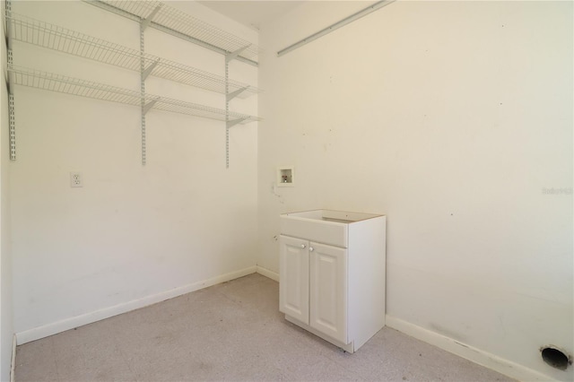 washroom with hookup for a washing machine and cabinets