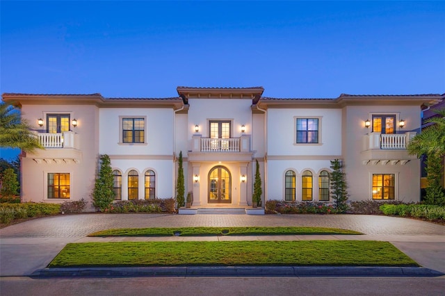 mediterranean / spanish-style home featuring french doors and a balcony