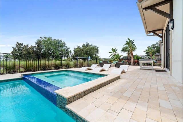 view of swimming pool featuring an in ground hot tub and a patio