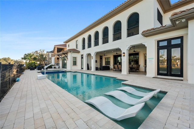 view of swimming pool with french doors, ceiling fan, and a patio area