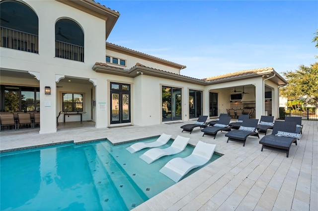 rear view of house with ceiling fan and a patio