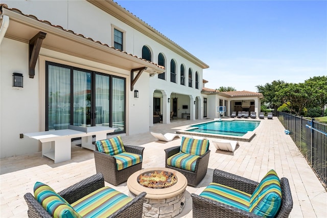 view of swimming pool with a wooden deck and an outdoor living space with a fire pit