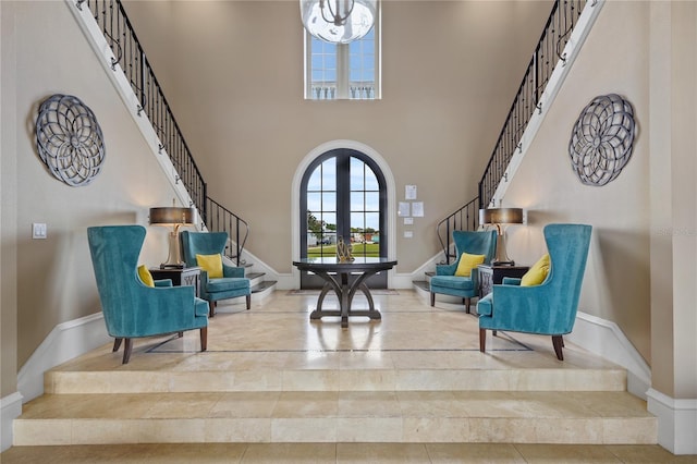 sitting room featuring a towering ceiling and french doors