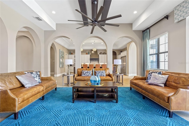 living room featuring tile patterned flooring, ceiling fan, and ornamental molding