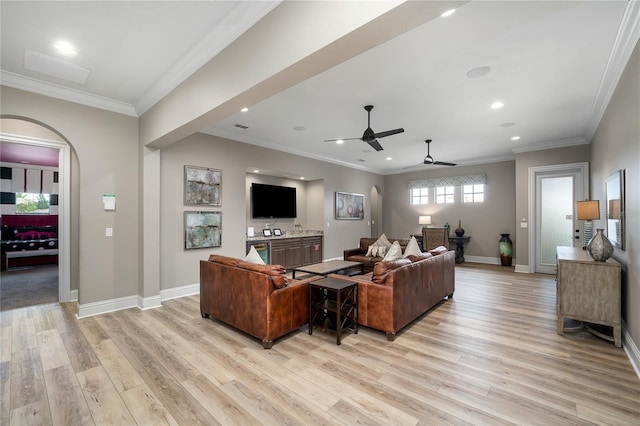 living room featuring ceiling fan, light wood-type flooring, and crown molding